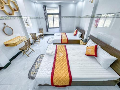 una stanza con due letti, un tavolo e delle sedie di HOMESTAY PHÚC LŨY a Cu Lao Thu