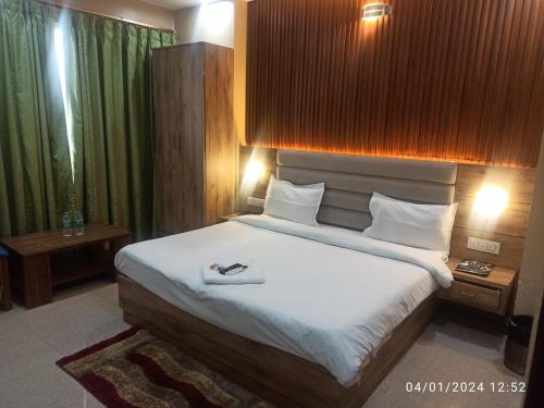 1 dormitorio con 1 cama grande con sábanas blancas en Icyhotels sunrise 92, en Noida