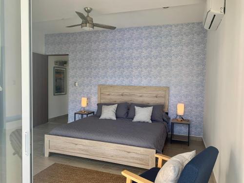 a bedroom with a bed and a blue wall at Departamento de Lujo & Club de Playa in Acapulco