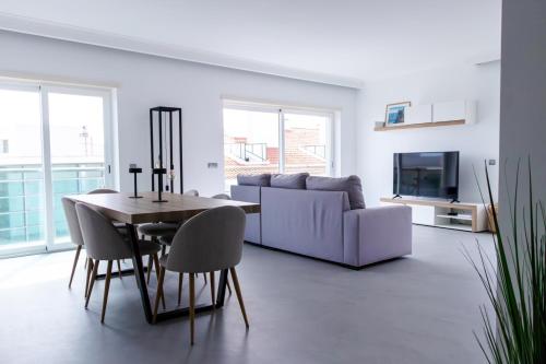 a living room with a table and a couch at Casa do Sal in Sesimbra