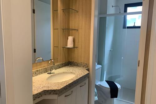 La salle de bains est pourvue d'un lavabo, de toilettes et d'un miroir. dans l'établissement Hosts BR - Apartamentos funcionais, à Fortaleza