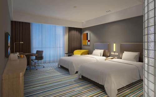 een hotelkamer met 2 bedden en een bureau bij Holiday Inn Express Zhangye, an IHG Hotel in Zhangye