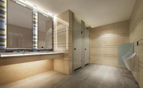 een badkamer met een grote spiegel en een wastafel bij Holiday Inn Express Zhangye, an IHG Hotel in Zhangye