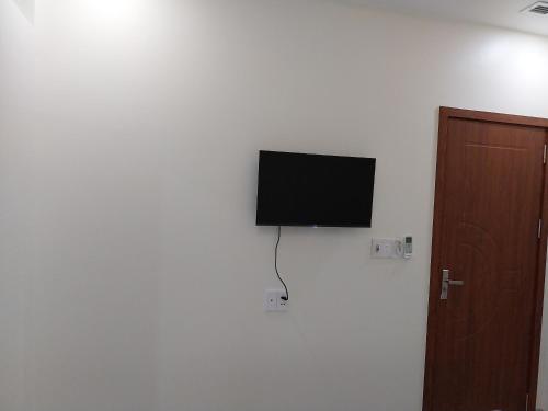 a flat screen tv on a wall next to a door at Tân Hiệp Hotel in Bùi Tiếng