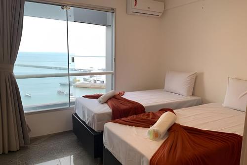 2 Betten in einem Zimmer mit Meerblick in der Unterkunft Hosts BR - Cobertura duplex frente mar in Fortaleza