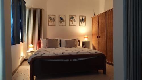 Il Cortiletto - Apartment في بيرغامو: غرفة نوم بسرير مع مصباحين وطاولتين