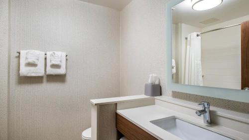 a bathroom with a sink and a toilet and a mirror at Holiday Inn Express & Suites Racine by IHG in Racine