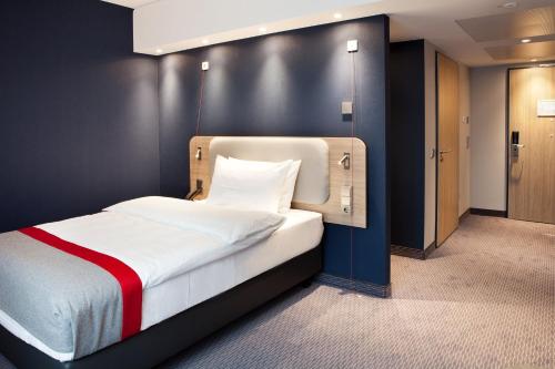 une chambre avec un lit avec un mur noir dans l'établissement Holiday Inn Express - Remscheid, à Remscheid