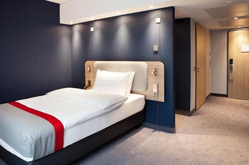 a bedroom with a bed with a black wall at Holiday Inn Express - Remscheid in Remscheid