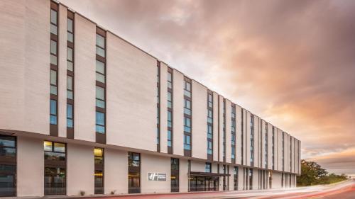 a large white building with a sunset in the background at Holiday Inn Express - Remscheid in Remscheid