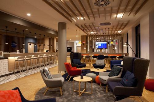 eine Lobby mit Sofas und Stühlen sowie eine Bar in der Unterkunft Holiday Inn Express - Remscheid in Remscheid