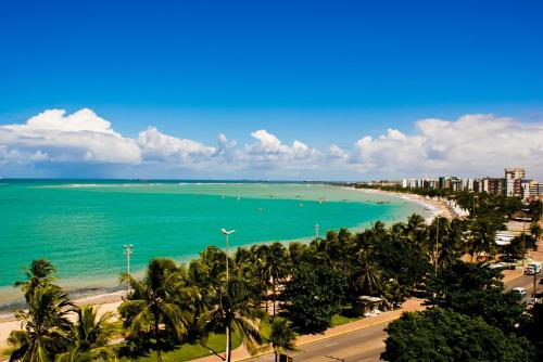 a view of a beach with palm trees and the ocean at Hilton Garden Inn Maceio in Maceió