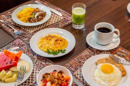 a table with plates of breakfast food and a cup of coffee at Hilton Garden Inn Maceio in Maceió