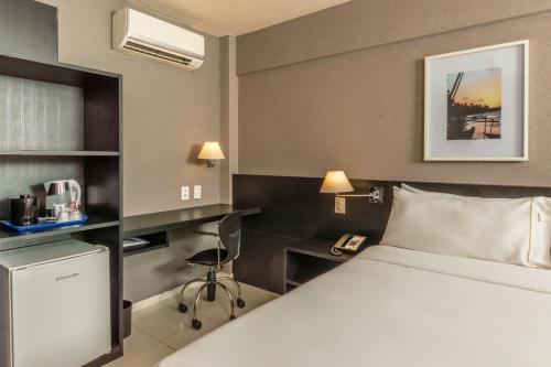 a hotel room with a bed and a desk at Hilton Garden Inn Maceio in Maceió