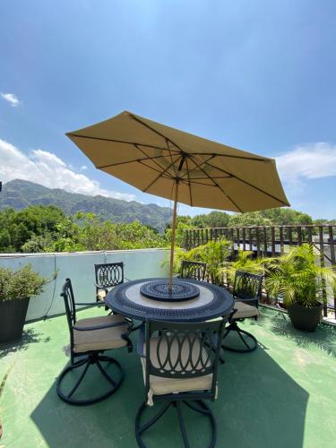 - une table et des chaises avec un parasol sur la terrasse dans l'établissement Posada Vista Tepoz, à Tepoztlán
