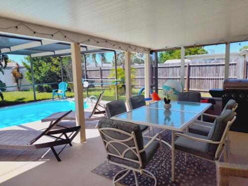 un patio con mesa y sillas junto a una piscina en Private & Screened in Pool, en Port Richey