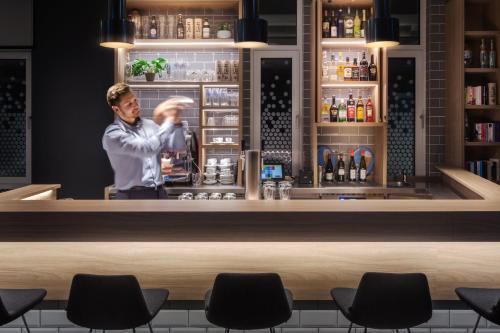 a man standing behind a bar at Holiday Inn Express - Erlangen by IHG in Erlangen