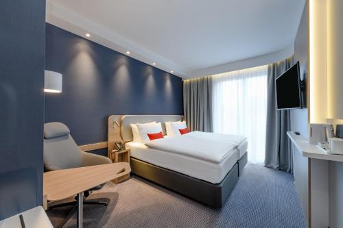 ein Hotelzimmer mit einem Bett und einem Schreibtisch in der Unterkunft Holiday Inn Express - Goettingen, an IHG Hotel in Göttingen