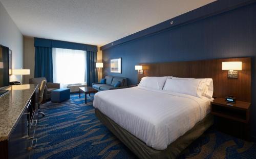 a hotel room with a large bed and a chair at Holiday Inn Express & Suites St. John's Airport, an IHG Hotel in St. John's