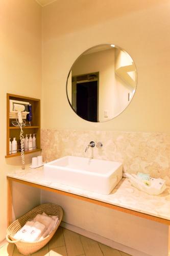 a bathroom with a sink and a mirror at Hotel Public Jam in Osaka