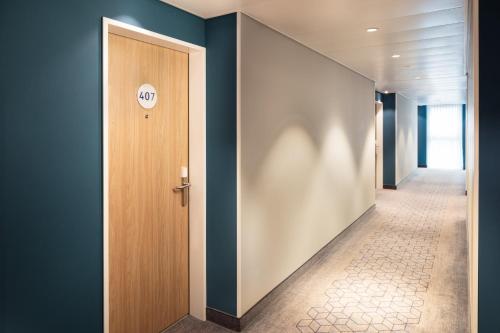a hallway with a door with a sign on it at Holiday Inn Express - Aarburg - Oftringen by IHG in Oftringen