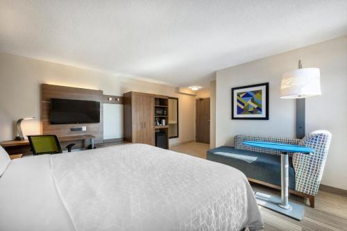 um quarto de hotel com uma cama, uma secretária e uma televisão em Holiday Inn Express Toronto Downtown, an IHG Hotel em Toronto