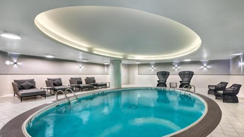 uma piscina no átrio do hotel com cadeiras e mesas em Crowne Plaza Toronto Airport, an IHG Hotel em Toronto