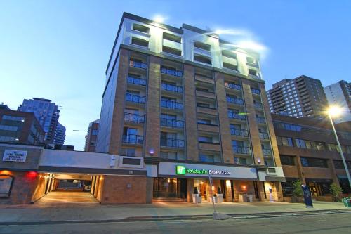 un edificio alto en una calle de la ciudad por la noche en Holiday Inn Express and Suites Calgary, an IHG Hotel, en Calgary