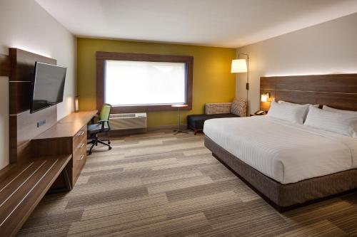 a hotel room with a bed and a flat screen tv at Holiday Inn Express & Suites Terrace by IHG in Terrace