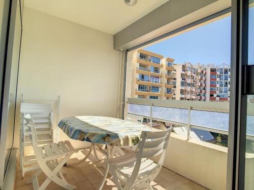 un balcon avec une table et deux chaises et une fenêtre dans l'établissement F2 Cabine avec Parking, Lave-linge, Lave-vaisselle, TV - FR-1-715-26, à Mauguio
