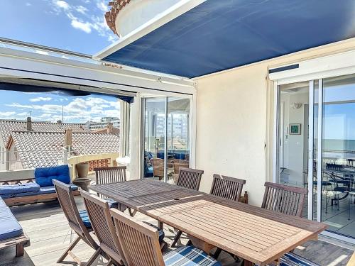une salle à manger avec une table et des chaises en bois dans l'établissement Appartement F4 Carnon avec terrasse, parking, climatisation, wifi, accès plage - FR-1-715-92, à Mauguio