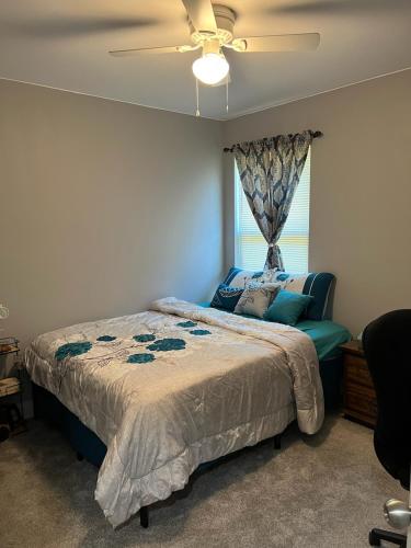 1 dormitorio con 1 cama, ventilador de techo y ventana en Lucky home, en Raleigh