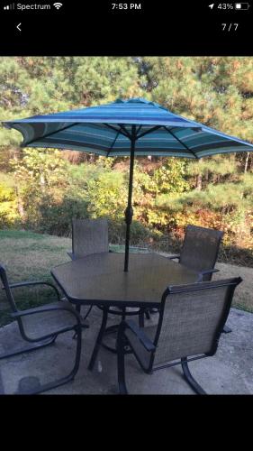 una mesa con 2 sillas y una sombrilla azul en Lucky home, en Raleigh