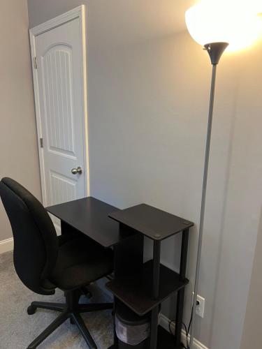 a black desk with a chair and a lamp at Lucky home in Raleigh