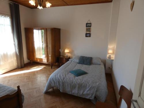 une chambre avec un lit avec un oreiller bleu dessus dans l'établissement Maison calme à Notre-Dame-de-Monts, 400m plage, animaux admis - FR-1-540-284, à Notre-Dame-de-Monts