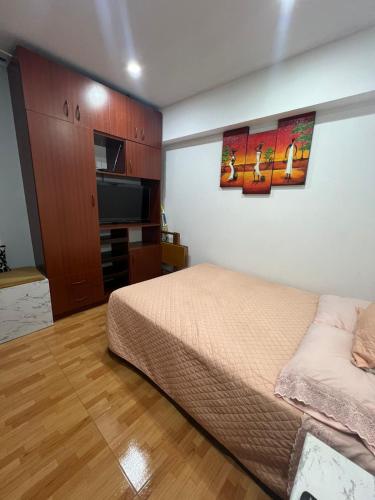 een slaapkamer met een bed en een flatscreen-tv bij Mini departamento in Trujillo