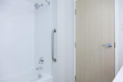 a shower with a glass door next to a sink at Holiday Inn Express Hotel & Suites Charlottetown, an IHG Hotel in Charlottetown