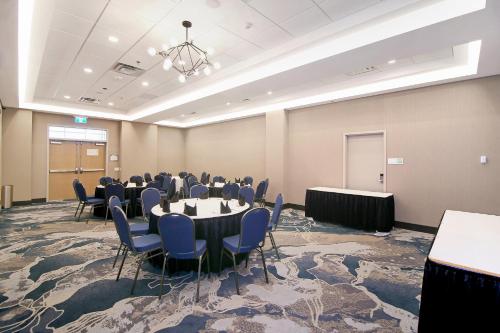 a conference room with tables and chairs in it at Holiday Inn Hotel & Suites - Calgary Airport North by IHG in Calgary