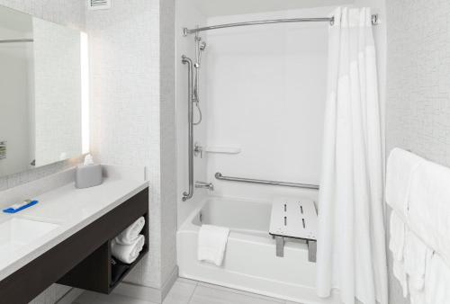 a bathroom with a shower curtain and a bathtub at Holiday Inn Express & Suites - Saskatoon East - University by IHG in Saskatoon