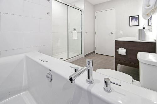 a white bathroom with a sink and a toilet at Holiday Inn Hotel & Suites - Calgary Airport North by IHG in Calgary