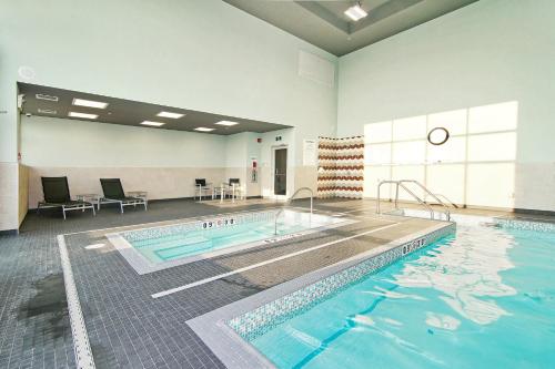 a large swimming pool in a building with a pool at Holiday Inn Hotel & Suites - Calgary Airport North by IHG in Calgary