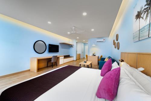 SGI Vacation Club Villa @ Damai Laut Holiday Resort في لوموت: غرفة نوم مع سرير كبير مع وسائد أرجوانية