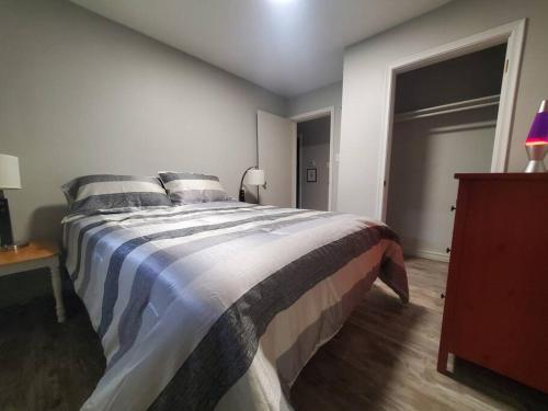 a bedroom with a large bed and a wooden floor at Central Private 1BR Apt. w/Free Prkg + Fast Wi-Fi in Sault Ste. Marie