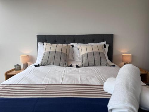 ein Schlafzimmer mit einem großen weißen Bett mit zwei Lampen in der Unterkunft Gold location Melbourne CBD in Melbourne