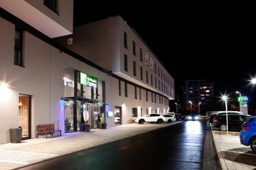 a city street at night with cars parked on the street at Holiday Inn Express - Trier by IHG in Trier