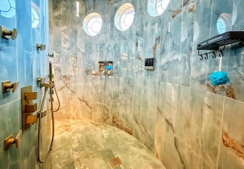 a bathroom with a shower with a marble wall at Luxury Palace / Vacation Home in Alvin