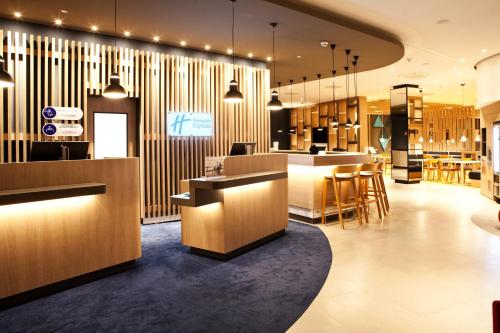 a lobby of a restaurant with a bar and tables at Holiday Inn Express - Göppingen by IHG in Göppingen