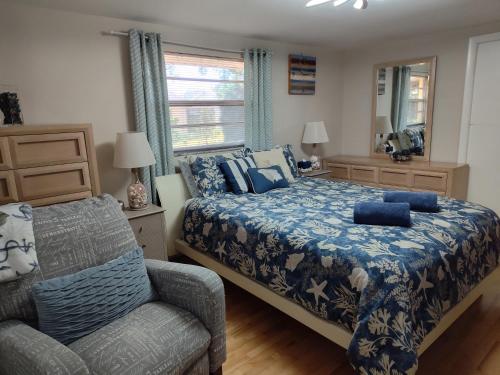 a bedroom with a bed and a chair and a window at Comfortable, Sunny, Quiet Neighborhood in Port Richey