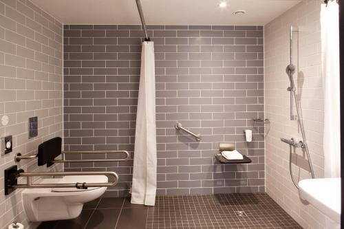 a bathroom with a shower and a toilet and a sink at Holiday Inn Express - Göppingen by IHG in Göppingen