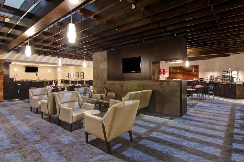 a lobby with a waiting room with chairs and a bar at Holiday Inn Oakville Centre by IHG in Oakville